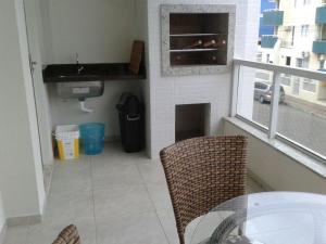 邦比尼亚斯Ótimo Apto. em Bombas的厨房配有桌子、水槽和窗户
