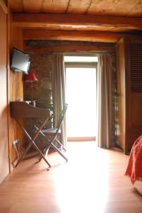 Anserall玛西亚登瓦伦蒂酒店的客房设有窗户、椅子和电视。