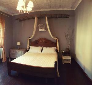 RovietoLa mia casa di campagna的一间卧室配有一张大床和木制床头板