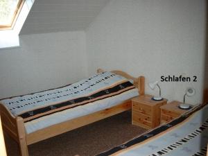 希尔兴巴赫Ferienwohnung Bäumener的一间卧室配有一张床、一张桌子和一个窗户。