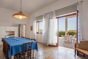 新福卡Villa Mare di Puglia m552的一间带蓝桌的用餐室和一间带庭院的房间