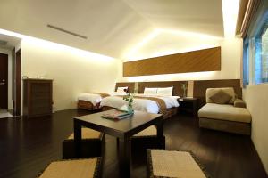 Fengping怡园度假村的酒店客房配有床、桌子和沙发。