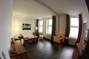 克劳斯塔尔采勒费尔德Hotel Goldene Krone的客厅配有沙发和桌子