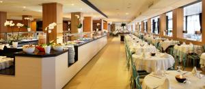 罗列特海岸Hotel Guitart Central Park Aqua Resort的一间设有白色桌椅和桌面的餐厅