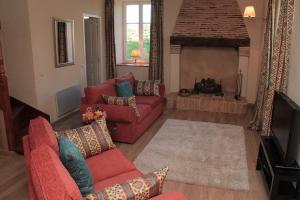 MontembœufLa Bucherie的客厅设有2张红色的沙发和壁炉