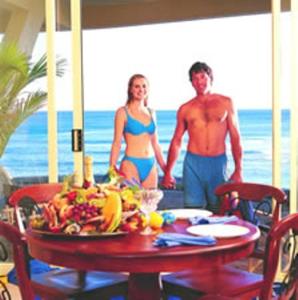 安特兰斯Al Mare Beachfront Retreat Award Winner的穿着泳衣的男人和女人站在桌子上