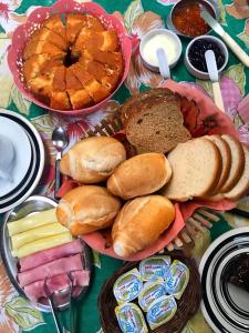 卡拉瓜塔图巴Pousada Tia Cleide的一张桌子上面有很多不同类型的面包