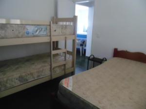 卡拉瓜塔图巴Sunny apartamentos de 1 e 2 dormitórios na Martin de Sá próximo a praia的小型客房配有2张双层床和1张床