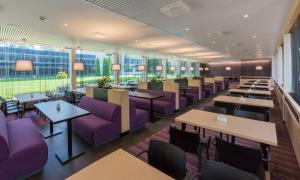 派尔努特维西Spa酒店的餐厅设有紫色家具、桌子和窗户