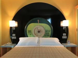 布伦巴泰谷歌里尔汽车旅馆的一间卧室配有一张带绿色苹果时钟的床