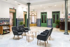 格拉纳达英拉特拉酒店的一间设有桌椅和绿门的等候室