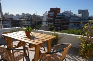 布宜诺斯艾利斯Ático Palermo的阳台上的木桌和椅子