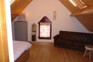 阿珀尔多伦In het koetshuis的一间卧室设有真皮沙发和窗户