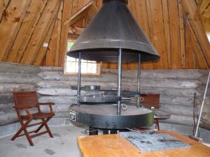 KarhujarviKarhujärven Kelopirtit的一个带桌椅的客房内的老炉子