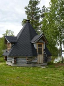 KarhujarviKarhujärven Kelopirtit的一间拥有黑色屋顶的小小木屋