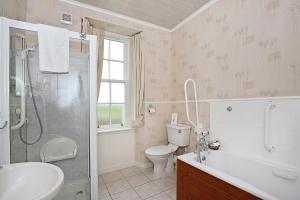 安斯特拉瑟The Spindrift Guest House的浴室配有卫生间水槽和淋浴。
