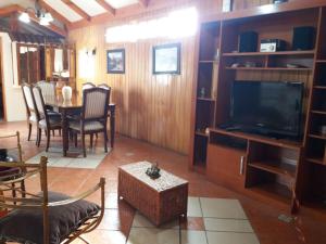 拉塞雷纳Casa La Serena的客厅配有电视和桌椅