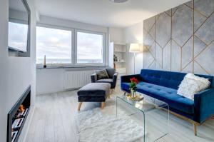 格丁尼亚Modern Place Apartament przy plaży的客厅配有蓝色的沙发和椅子