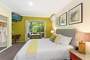 麦夸里港豪斯蔚然海岸住宿加早餐旅馆的卧室设有一张白色大床和绿色的墙壁