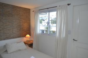 圣萨尔瓦多德朱Guest House Jujuy的一间卧室设有床、窗户和一盏灯。