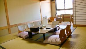 阿智村汤多利里伊那华日式旅馆的配有桌子、椅子和桌子的房间