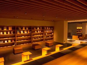 金泽金泽雨庵酒店的图书馆设有长椅和书架