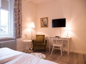 特拉诺斯Hotel Åberg Centralhotellet的酒店客房设有一张床、一张书桌和一台电视机。