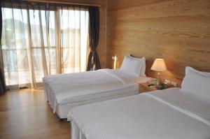 科罗尔帕劳天堂岛渡假村俱乐部的酒店客房设有两张床和窗户。