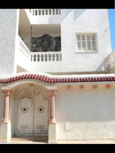 哈曼苏斯Nice Holiday Apartment Hammam Sousse的白色的建筑,设有门和阳台