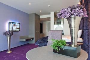 卢布尔雅那G设计酒店的一张桌子上放着两瓶紫色花的花瓶的房间
