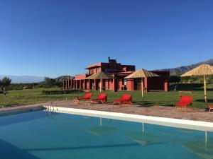 Fuerte QuemadoFinca Albarossa的一个带椅子的游泳池和一个背景房子