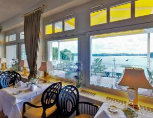 巴特塞格贝格维达利亚海滨酒店的一间带桌椅的用餐室和大窗户