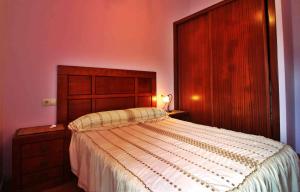 孔门波尔多Casa Caramanchon的一间卧室配有一张大床和木制床头板