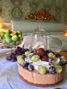 丘西Residenza Dei Ricci的一块玻璃盘上的蛋糕,桌上有水果