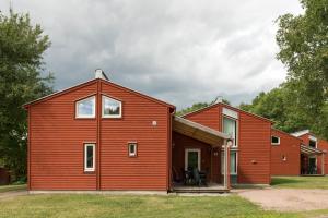 韦斯特罗斯First Camp Västerås-Mälaren的一间拥有红色外墙的谷仓风格房屋