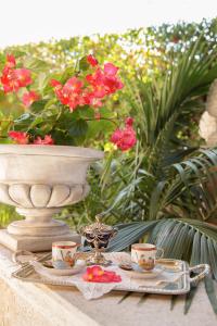 罗马奥瑞尼套房酒店的一张桌子,上面有两个茶杯,花瓶