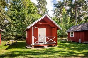 卡尔马First Camp Stensö-Kalmar的草上一个红色的棚子,有一道白色的门