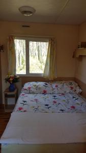 什切齐内克Przystań Bosmanat的一间卧室配有一张带花卉床罩的床和窗户。