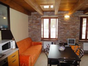 帕苏德尔托纳莱SCI AI PIEDI,PASSEGGIATE,MOUNTAIN BIKE,RELAX的客厅配有橙色沙发和桌子