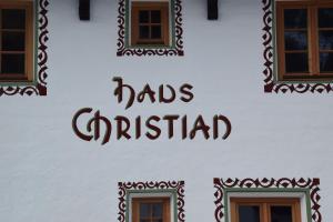 尼德泰Haus Christian的白色的建筑,上面有读过帽子的标志