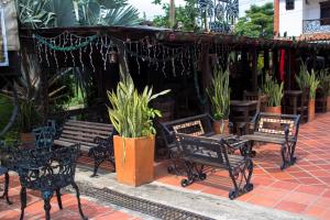 库库塔Posada El Abuelo的一组长凳、桌子和盆栽植物