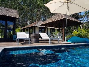 阁遥岛Koyao Bay Pavilions - SHA Extra Plus的一个带两把椅子和遮阳伞的游泳池