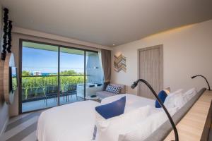 卡塔海滩The SIS Kata, Resort - SHA Plus的酒店客房设有一张床和一个阳台。
