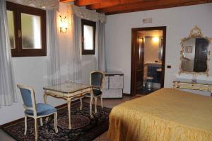 雷扎托梦想酒店的卧室配有一张床和一张桌子及椅子