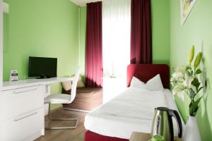 杜塞尔多夫巴塞罗那住宿&早餐酒店的一间卧室配有一张床和一张带电脑的书桌
