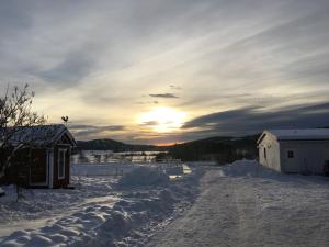 LerbäckenLilla Vrån的一条雪覆盖的道路,在背后是日落