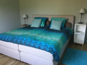 GenoelselderenBelle Vue Vakantieappartement的一间卧室配有一张大床,提供蓝色的床单和枕头