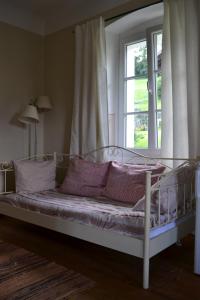 TrebesingAltes Pfarrhaus Altersberg的窗户客房内的一张带紫色枕头的床