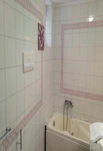 萨莱诺Il sorriso的白色瓷砖浴室设有浴缸和镜子