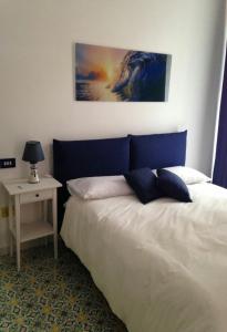 萨莱诺Il sorriso的一间卧室配有一张带蓝色床头板的床和一张桌子